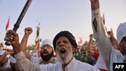 Pakistani supporters of Canada-based preacher Tahir-ul Qadri shout anti-government slogans during a protest in front of the Parliament in Islamabad on August 27, 2014.