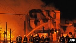 Firefighters try to extinguish a burning 140-year-old furniture store in Croydon, South London, during the early August riots.