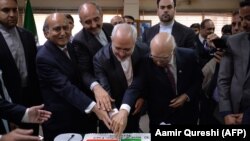 Iranian Foreign Minister Mohammad Javad Zarif (C) cuts a cake during an event to mark 70 years of Pakistan-Iran relations during an event at the Institute of Strategic Studies in Islamabad on March 12.