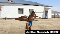 Су таситын ыдыс көтеріп келе жатқан бала. Көмекбаев ауылы, Қызылорда облысы, 16 шілде 2013 жыл.