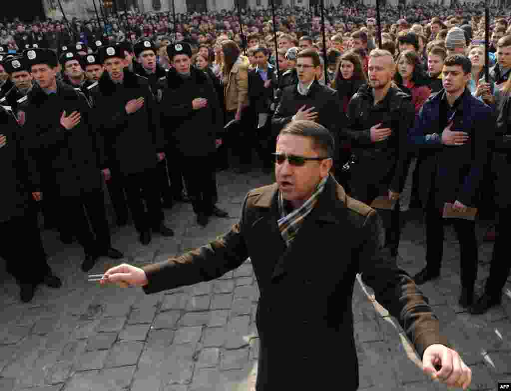 Ukrainian police cadets and citizens sing the national anthem during an event in the center of Lviv. Some 3000 people took part in the event marking the 150th annivertsary of the first rendering of the national anthem of Ukraine. (AFP/Yuriy Dyachyshyn)