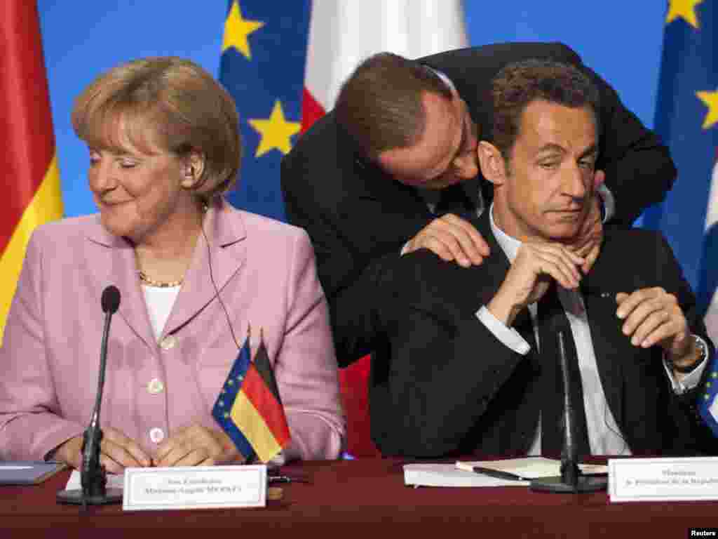 Italian Prime Minister Silvio Berlusconi (C) speaks with France's President Nicolas Sarkozy and German Chancellor Angela Merkel (L) during a news conference following a summit to discuss the international financial crisis at the Elysee Palace October 4, 2008. REUTERS/Philippe Wojazer 