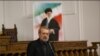 Iran Parliament Speaker Ali Larijani speaking under a poster of Ayatollah Ali Khamenei