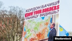 Плакат с изображением российского президента Владимира Путина на акции протеста против аннексии Россией украинского Крыма