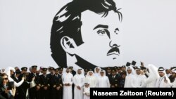 Политики, военные и бизнесмены Катара на фоне портрета своего правителя, эмира Тамима бин Хамада Аль Тани