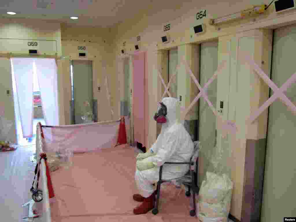 A worker sits in the service building for two of the reactors.