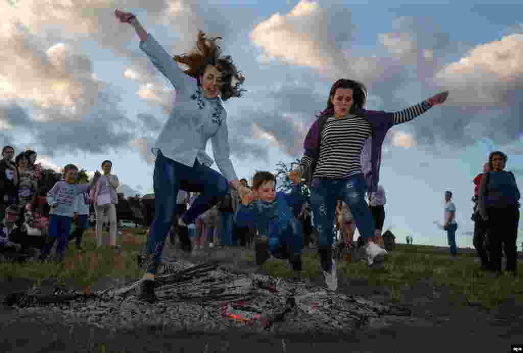 People jump over a bonfire during celebrations for Ivana Kupala, an ancient heathen holiday, in the village of Pyrohove, near Kyiv, on July 7. (epa/Sergey Dolzhenko)