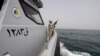 SAUDI ARABIA - A Saudi border guard watches as he stands in a boat off the coast of the Red Sea on Saudi Arabia's maritime border with Yemen, near Jizan April 8, 2015