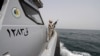 SAUDI ARABIA - A Saudi border guard watches as he stands in a boat off the coast of the Red Sea on Saudi Arabia's maritime border with Yemen, near Jizan April 8, 2015