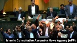 Iranian MPs burn a US flag in the parliament in Tehran, May 9, 2018, after U.S. President Donald Trump announced withdrawal from the Iran nuclear deal.