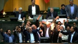 Iranian MPs burn a US flag in the parliament in Tehran, May 9, 2018, after U.S. President Donald Trump announced withdrawal from the Iran nuclear deal.