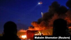 Вертолёт тушит пожар в торговом центре "Синдика" в Москве. 8 октября 2017.