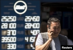 Мужчина у пункта обмена валют в день, когда упал курс тенге. Алматы, 20 августа 2015 года.