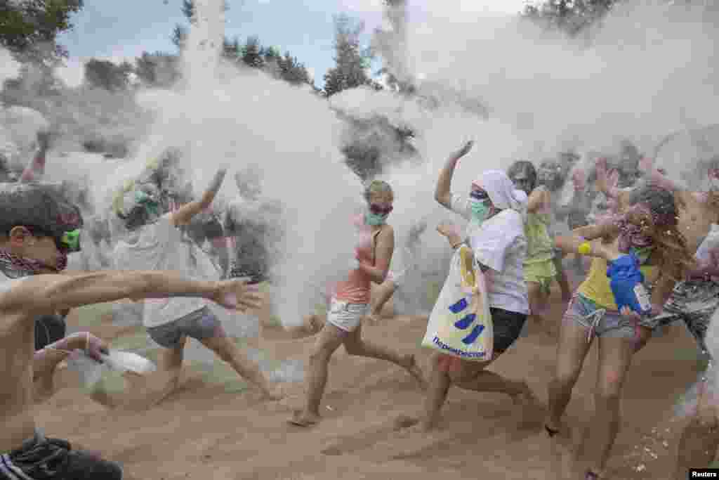Youths throw flour at each other during a flash mob on the banks of the Dnipro River in Kyiv, Ukraine. About 100 people participated in the flash mob. (Reuters/Valentyn Ogirenko)