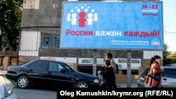 Люди на улице города Симферополя проходят мимо билборда, оповещающего о переписи населения. 
