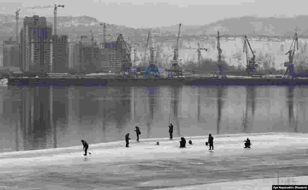 Men fish on the ice-covered Yenisei River in Krasnoyarsk, Russia. (Reuters/Ilya Naymushin)