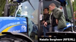 Fermieri examinează un tractor la expoziția agricolă „Farmer”, la Chișinău. 