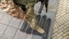 უკრაინელი სამხედრო ფეხს აბიჯებს აბრებს რუსეთის ქალაქების წარწერებით. ოდესა, 14 აპრილი, 2022.