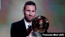 Futbollisti Lionel Messi duke e mbajtur çmimin Topi i Artë