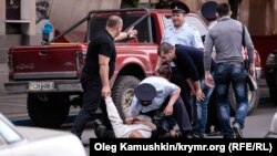 Rusiyanın xüsusi təyinatlı polis dəstəsi üzvləri Simferepolda mitinq keçirmək istəyə tatarlardan birini həbs edir. 