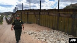A U.S. security officer patrols along a border fence with neighboring Mexico designed to keep out illegal immigrants. 