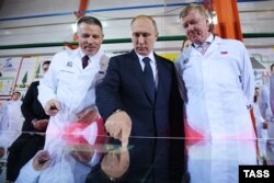 Russian President Vladimir Putin (center) visits a new production line in Chelyabinsk with Anatoly Chubais (right) in December 2016.