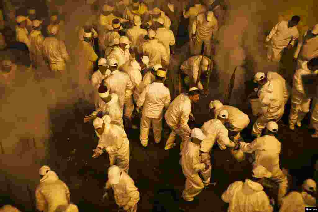 Members of the Samaritan religious sect seal an oven after filling it with large sheep skewers during a traditional Passover sacrifice ceremony on Mount Gerizim, near the West Bank city of Nablus. (Reuters/Nir Elias)