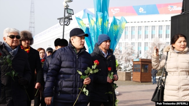 Активист Жанболат Мамай и другие инициаторы создания Демократической партии Казахстана возлагают цветы к монументу Независимости. Алматы, 16 декабря 2019 года.