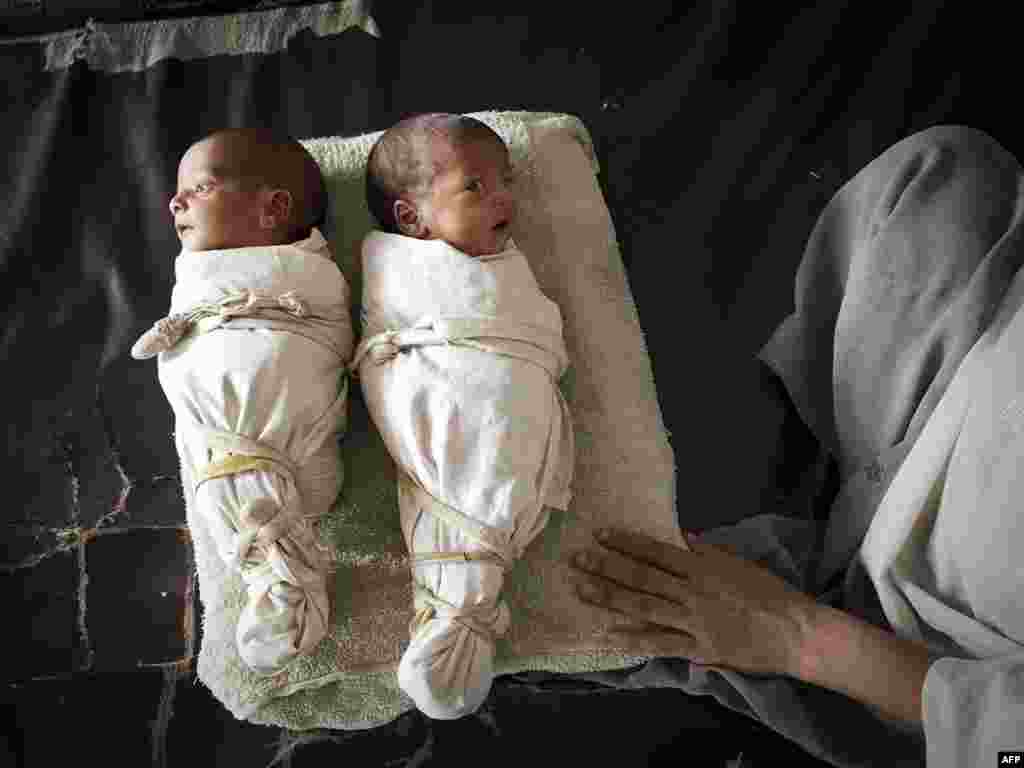 Pakistani mother Bushra Humayoun watches over her twins Abdullah Khan (left) and Muhammed Bilal in the field hospital were they were born at a college converted to a camp for flood survivors by the army on the outskirts of Nowshera on August 12. Pakistan's government says 14 million people are facing direct or indirect harm because of floods, with children especially vulnerable. Photo by Behrouz Mehri for AFP