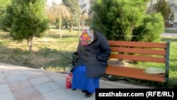 Спящая на скамейке женщина в парке в Туркменистане.