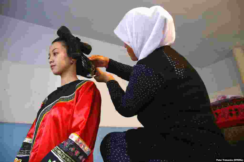 The traditional bride&#39;s hairstyle is made using hair gel and threads that hold the hair together. This art is passed from generation to generation of Dungan women.