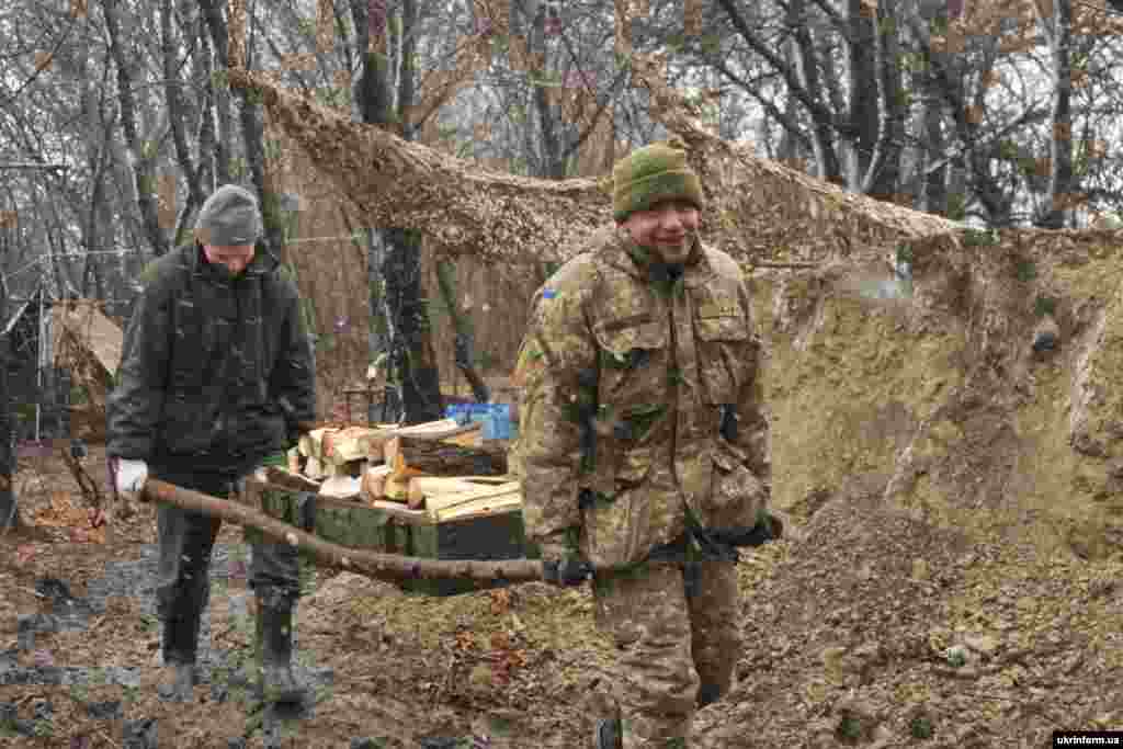 Бійці переносять підвезені дрова до бліндажу на передовій. Донецька область, грудень 2015 року