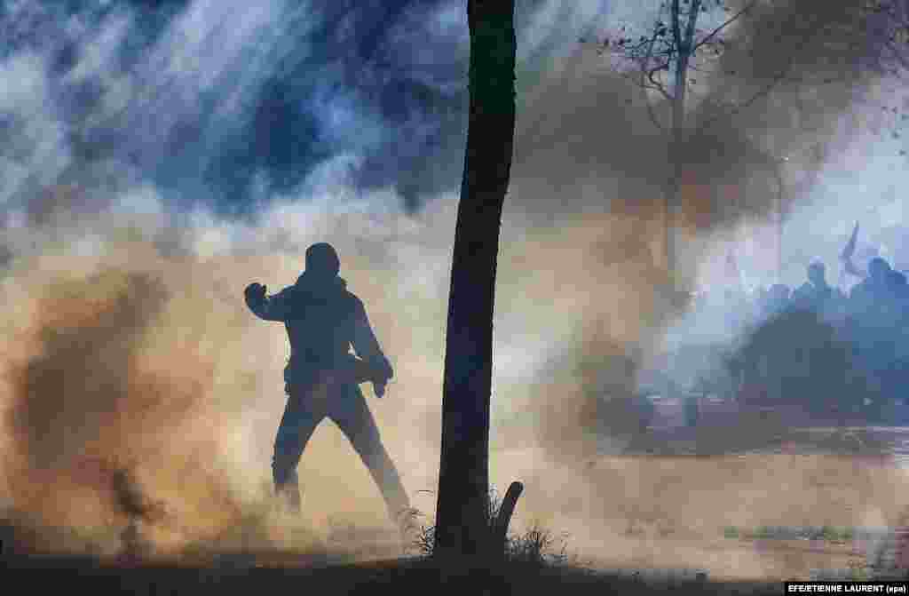 A protester is silhouetted in tear gas during clashes with riot police amid a demonstration against the French government's labor reforms in Paris on September 21. (epa-efe/Etienne Laurent)