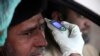 A health official checks the temperature of a government employee in Peshawar on March 12. 