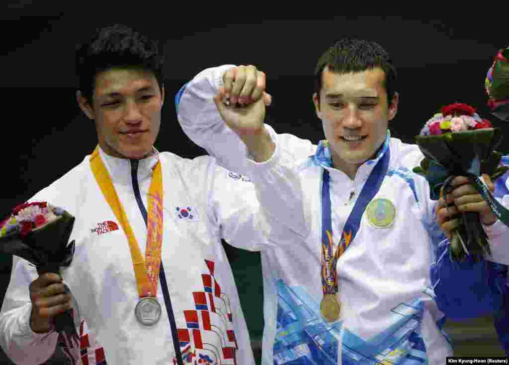 Казахстанский боксер Адильбек Ниязымбетов (слева), выступающий в весовой категории до 85 иклограммов, стал чемпионом Азиатских игр. Инчхон, 3 октября 2014 года. 