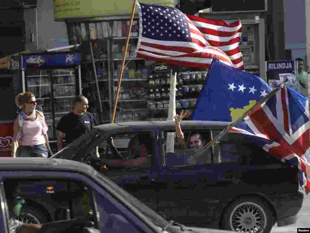 Passengers wave the U.S., Kosovo, and British flags as they celebrate in Pristina after the International Court of Justice said Kosovo's declaration of independence was legal on July 22, a decision with implications for separatist movements everywhere. Photo by Hazir Reka for Reuters