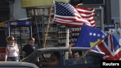 Kosovars wave the U.S., Kosovo, and U.K. flags as they celebrate in Pristina on July 22, 2010, after the World Court said Kosovo's declaration of independence was legal.
