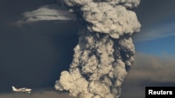 A plane flies past a smoke plume from the eruption of the Grimsvotn volcano in Iceland on May 21.