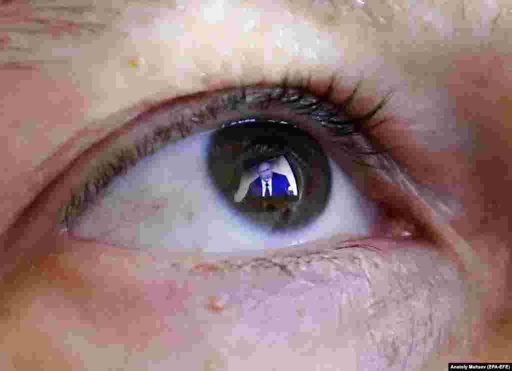 Russian President Vladimir Putin is reflected in an eye of a woman during his annual end-of-year news conference in Moscow on December 19. (epa-EFE/Anatoly Maltsev)