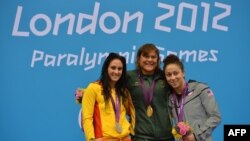 American bronze medalist Elizabeth Stone (right) joins Spanish silver medalist Sarai Gascon (left) and South African gold medalist Natalie du Toit on the podium after the women's 100-meter backstroke finals in London on August 31.