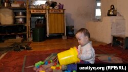 Мальчик играет на полу одной из двух комнат, которая служит и кухней.