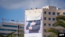 Сорванный портрет низложенного тунисского президента Бен Али на здании в пригороде столицы страны