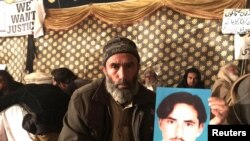 Mohammad Bilal holds a picture of his son Hazratullah as he takes part in a protest with members of the Pashtun community against what they say are enforced “disappearances” and routine oppression, in Islamabad on February 8.