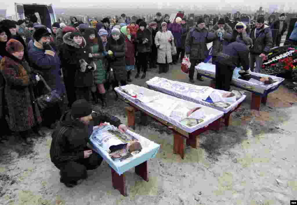 Relatives and friends attend the funerals for Nikolay and Lyubov Bobilev, their daughter Marina Kashina, and their 3-year-old grandson Vyacheslav, of whom were killed during the January 24 shelling of the eastern Ukrainian city of Mariupol. (epa/Sergei Vaganov)