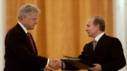 Russian President Vladimir Putin (right) and US President Bill Clinton exchange agreements on the establishment of a joint warning center for the exchange of information on missile launches shortly after signing them, in Moscow on June 4, 2000.