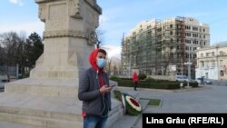 Un tânăr cu masca pe față asteaptă lângă monumentul lui Ștefan cel Mare din centrul Chișinăului. Autoritățile au decretat cod rosu de urgență sanitară sâmbătă, 14 martie 2020.