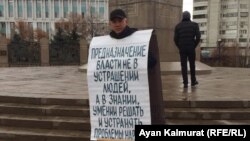Алматыда Тәуелсіздік күні қарсаңында "бейбіт жиын өткізу тәртібін бұзды" деп айыпталып, қамалған белсенділердің бірі Асхат Жексебаев жалғыз адамдық пикетте тұр. Қараша айы, 2019 жыл.