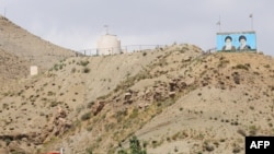 Posters of Iran's late Ayatollah Ruhollah Khomeini (L) and Ayatollah Ali Khameni (R), are seen on the top of a hill from the Turkish side of the border near the Esendere crossing between Turkey and Iran. File photo