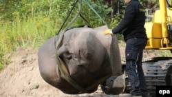 A workers secures a giant Lenin head exhumed from a forest in Berlin on September 10.