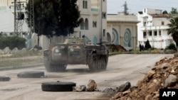 Хомс қаласының Әл-Ваар ауданына рейд жасап жүрген үкімет күштерінің танкі. Сирия, 2 мамыр 2012 жыл.